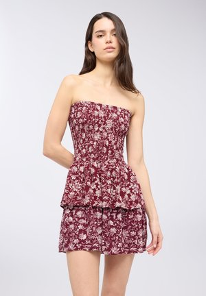 Vestito senza spalline bordeaux con busto arricciato e orlo a strati. Presenta un motivo floreale in crema. Realizzato in tessuto leggero.