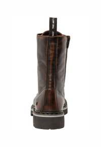 Bottines en cuir marron avec une texture lisse, fermeture éclair sur le côté et boucle de tirage. Semelle durable avec un détail de surpiqûre contrastant.