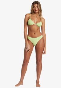 Ljusgrön, ribbad bikini med triangeltopp och hög midja. Har tunna band och minimala metalldetaljer. Slät yta.