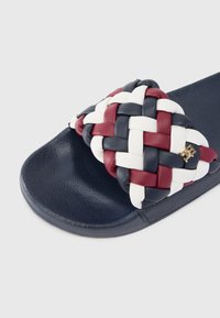 Μπλε σαγιονάρα ναυτικού χρώματος με πλεχτό άνω μέρος σε κόκκινο, λευκό και μπλε. Διαθέτει υφή στη σόλα και μια μικρή χρυσή λεπτομέρεια λογότυπου.