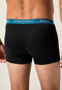 Černé bavlněné boxerky s elastickým lemem v barvě teal s logem "JP1880". Hladký povrch a přiléhavý střih, viděno z zadního pohledu.
