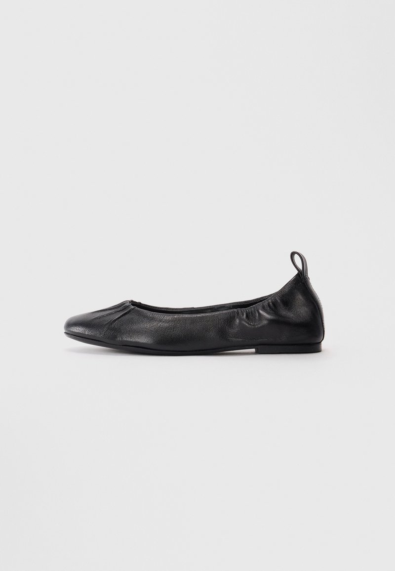 Black leather ballet flat with rounded toe, gathered elastic sides, and a pull tab at the heel, displayed on a light background.