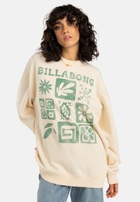 Crème sweatshirt met groene grafische print van bloemen en vormen, met een geribbelde halslijn en manchetten. Casual oversized pasvorm.