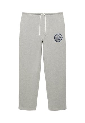 Hellgraue Jogginghose mit weißem Kordelzug und einem kleinen marineblauen, runden Emblem am rechten Oberschenkel, das Text und Grafiken zeigt.