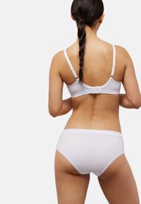 Conjunto de sujetador y braga de algodón blanco con tirantes ajustables, diseño sin costuras, textura suave y sin adornos, visto desde atrás.