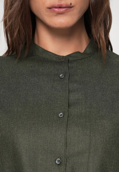 Cămașă de culoare verde închis, cu guler, realizată dintr-un material texturat, având șase nasturi negri și un design simplu, structurat, fără modele vizibile.