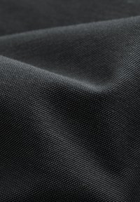 Texturerad svart tyg med ett subtilt vävmönster, som visar en mjuk matt finish och lätt veckning. Lämplig för olika tillämpningar.