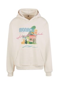 Světle béžová mikina s kapucí a přední kapsou, která má barevnou grafiku Monaka, s palmami a designem budovy.