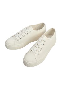 Białe płócienne trampki z okrągłym noskiem, płaską gumową podeszwą, metalowymi oczkami i białymi sznurowadłami. Gładka tekstura z minimalistycznymi elementami designu.