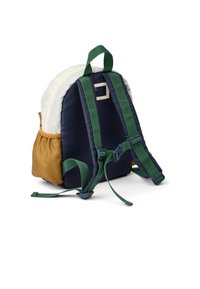 Multicolored backpack in navy blue, cream, and brown fabric. Features adjustable green straps, a top handle, and textured accents.
