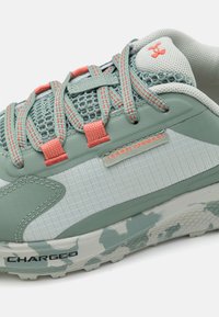 Sneaker verde menta con materiale in rete e sintetico, con accenti corallo, suola in gomma testurizzata con motivo camouflage e marchio "Charged".