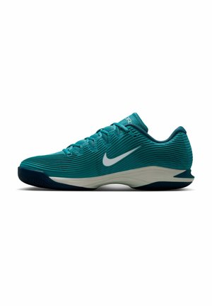 Teal lage Nike sportschoen met gestructureerde zijkanten, wit swoosh-logo en zwarte zool, zijaanzicht op een witte achtergrond.
