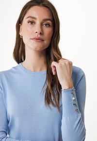 Pullover azzurro chiaro con scollatura a girocollo, texture a coste e maniche lunghe con dettagli in bottone dorato sui polsi.