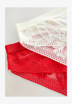 Hvid- og rød blondeundertøj med blomsterdesign, lagt over en lys overflade.