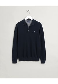 Marineblaues Langarm-Polo aus strukturiertem Stoff, mit Kragen, drei Knöpfen und einem kleinen gestickten Logo auf der Brust.