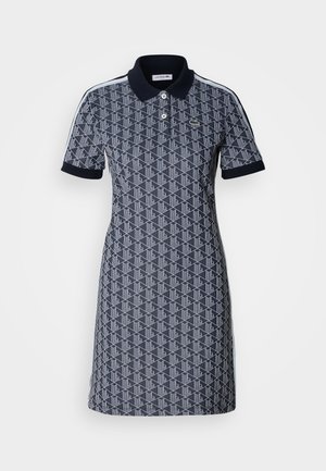 Robe polo bleu marine avec motif géométrique, col, manches courtes et accents blancs sur les épaules. Fabriquée en tissu respirant.