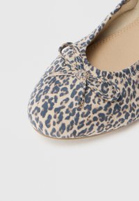 Μπαλαρίνα με λεοπάρ σχέδιο και μαλακό υφασμάτινο πάνω μέρος σε κρεμ και μπλε απόχρωση. Διαθέτει διακοσμητική κορδέλα στη μύτη και λείο εσωτερικό φόδομα.