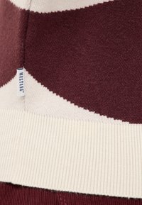 Pruhovaný svetr v burgundské a smetanové barvě, s žebrovaným lemem a štítkem s nápisem "MUSTANG", měkká textilie s mírně chlupatým povrchem.