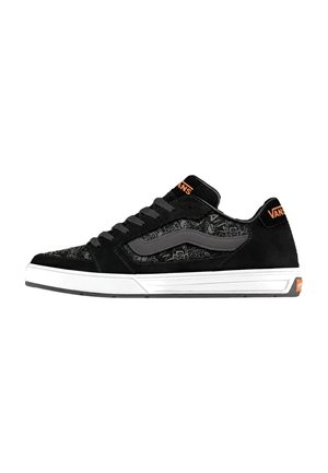 Black Vans low-top sneaker with grey side stripe, subtle pattern, white sole, black laces, and orange Vans logo on heel and tongue.