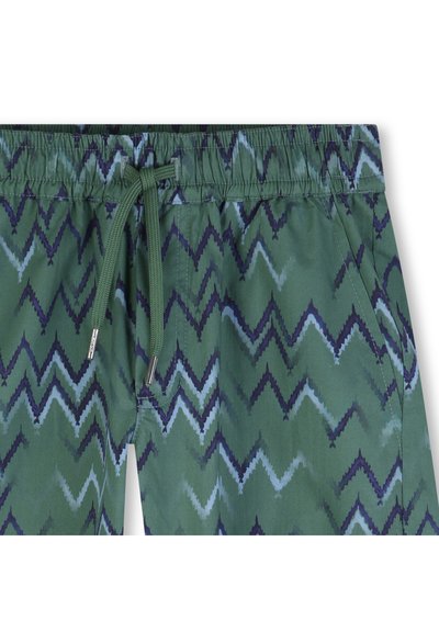 Πράσινο μαγιό σορτς με ζιγκ-ζαγκ σχέδιο σε μπλε και ναυτικό μπλε. Διαθέτει ελαστική μέση με κορδόνι και πλαϊνές τσέπες.