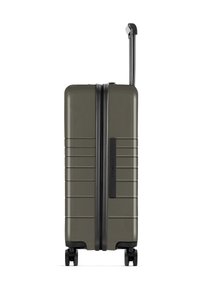 Hartschalenkoffer in Olivgrün mit strukturierten Oberflächen, horizontalen Rillen, einem schwarzen Reißverschluss und einem ausziehbaren Griff. Vier Räder für Mobilität.