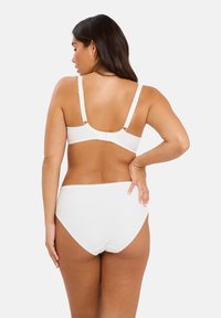 Top de bikini blanco de canalé con tirantes ajustables y cierre de gancho, combinado con braguitas de talle alto a juego con bordes en forma de onda.