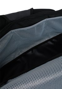 Interior de bolsa negra con bolsillo de malla en gris claro y tela negra suave. Incluye cierre con cremallera y compartimentos distintos para organización.