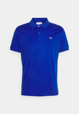Polo bleu à manches courtes avec deux boutons et un petit logo crocodile vert sur la poitrine gauche.