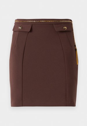 Brown fitted mini skirt with gold chain belt, decorative buttoned flaps, and gold tassel detail on a plain background.