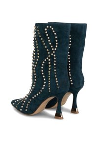 Cizme de gleznă din piele intoarsă verde închis, cu vârf ascuțit, decorate cu nituri metalice și modele în valuri, având tocuri subțiri cu accente aurii.