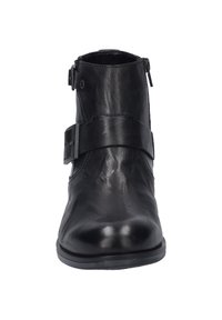 Botte de cheville en cuir noir avec une texture lisse, fermeture éclair latérale et une large sangle décorative. Bout arrondi et semelle plate.