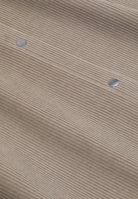 Jasno beżowa tkanina sztruksowa z wyraźnymi pionowymi prążkami, z dwoma metalowymi zatrzaskami w kolorze srebrnym umieszczonymi na powierzchni.