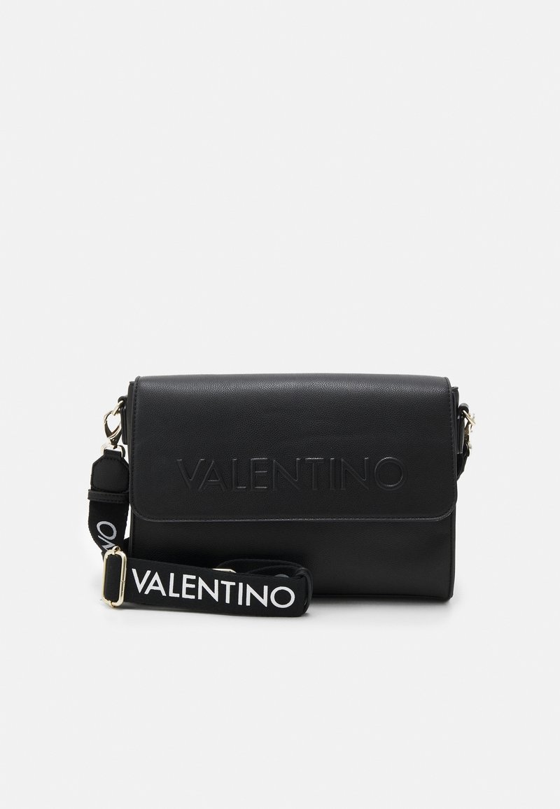 Borsa nera Valentino con logo in rilievo sul davanti e tracolla rimovibile con il nome del marchio in bianco.