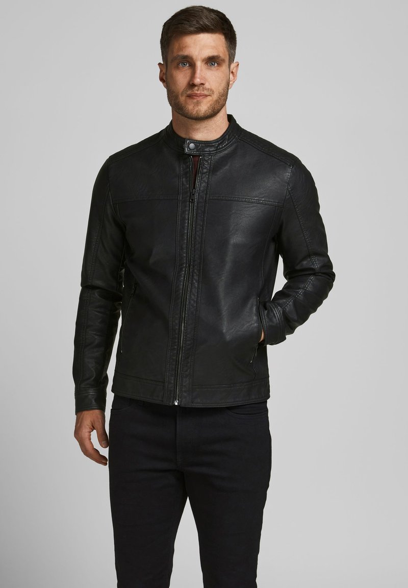 Veste en cuir noir avec col montant, fermeture éclair à l'avant et poches latérales. Finition texturée et détails de surpiqûres subtils. Design slim fit.