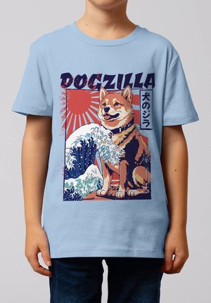 Child wearing light blue shirt with "Dogzilla" graphic of a Shiba Inu dog, stylized ocean waves, and a rising sun background with Japanese text.