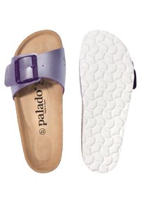 Sandale en cuir violet à enfiler avec une grande boucle, semelle intérieure en liège et semelle extérieure en caoutchouc blanc texturé. Logo de la marque visible sur la semelle intérieure.