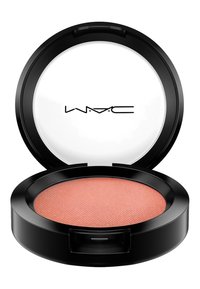 Compact de blush MAC avec un boîtier noir rond, comportant un intérieur en poudre rose pêche avec une surface texturée et un couvercle intérieur transparent.