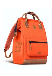 Sac à dos en toile orange avec des accents en cuir marron, grande poche principale, poche zippée à l'avant et trois boucles latérales pour fixation.