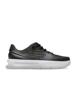 Schwarzer Sneaker mit niedrigem Schnitt, perforierten Seiten, schwarzen Schnürsenkeln und dicker weißer Sohle, dargestellt auf weißem Hintergrund.