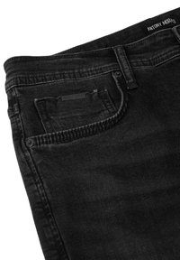 Los jeans de mezclilla negra cuentan con un diseño clásico de cinco bolsillos y una etiqueta de cuero en el bolsillo trasero. La tela tiene un acabado liso y texturizado.