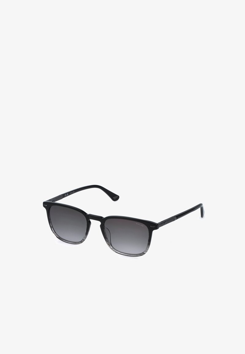 Lunettes de soleil noires à monture carrée avec verres dégradés foncés et branches fines sur fond blanc.