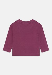 Langärmliges Shirt aus dunkelviolettem Baumwollstoff. Verfügt über einen runden Halsausschnitt und gesäumte Bündchen. Glatte Textur ohne sichtbare Muster oder Akzente.