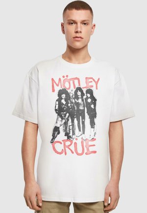 Valkoinen puuvillapaita, jossa on musta graafinen printti neljästä hahmosta ja "MÖTLEY CRÜE" punaisella tekstillä. Iloisesti istuva, lyhyet hihat.