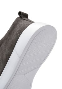 Sneaker in suede grigio con suola in gomma bianca, caratterizzata da una suola testurizzata e un inserto in tessuto sul tallone.