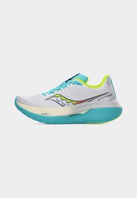 Λευκό και τιρκουάζ αθλητικό παπούτσι με επένδυση νέον κίτρινου, ανοιχτά μπλε κορδόνια και ενισχυμένη σόλα, σχεδιασμένο για άνεση και απόδοση.