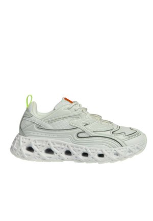Baskets blanches de sport avec des motifs ondulés complexes, des détails en mesh, et une semelle épaisse comportant des découpes géométriques ainsi qu'une boucle de talon vert néon.