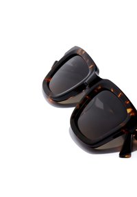 Ochelari de soare supradimensionați, negri și cu model țestoasă, cu lentile întunecate. Ramă dreptunghiulară cu textură netedă și margini bine definite, prevăzută cu brațe robuste.