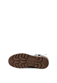 Black and white shoe with a textured rubber sole, featuring a wave pattern. Laces are integrated, and accent details are minimal.