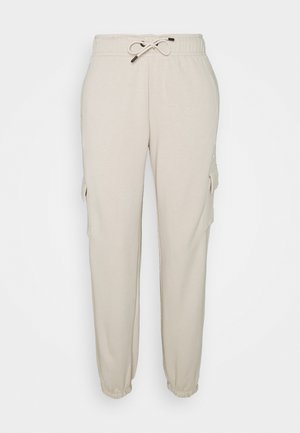 Beige sweatpants met een elastische tailleband en trekkoord, met zijbuideltassen en taps toelopende boorden. Zacht, lichtgewicht materiaal.