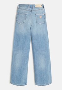 Vaaleansinisenä leveälahkeiset farkut, joissa on korkea vyötärö. Farkuissa on hillitty haalistuma, kaksi takataskua ja pieni logotunniste vyötäröllä.